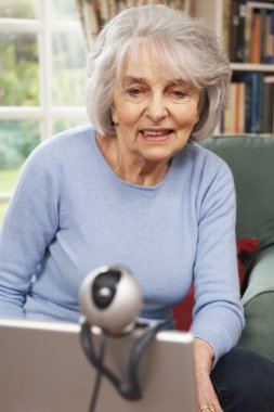 Aile ile konuşmak için web kamerası kullanarak kadın kıdemli