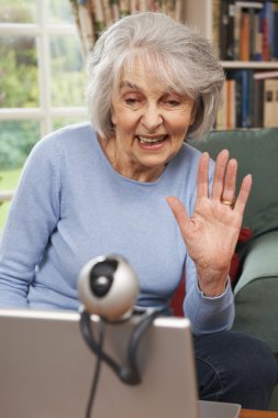 Aile ile konuşmak için web kamerası kullanarak kadın kıdemli