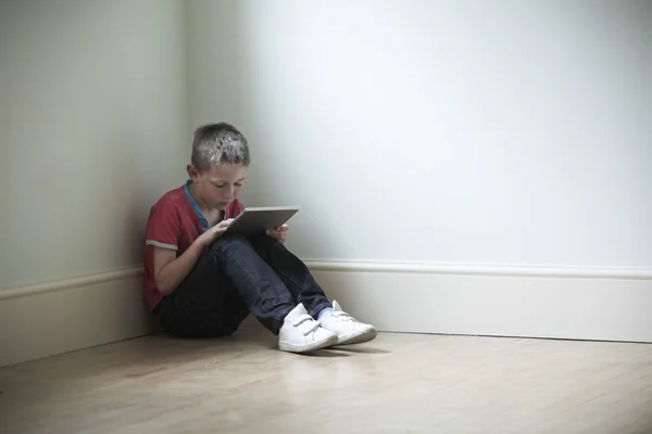 Olyckliga barn sitter i rummet med digitala tablett — Stockfoto