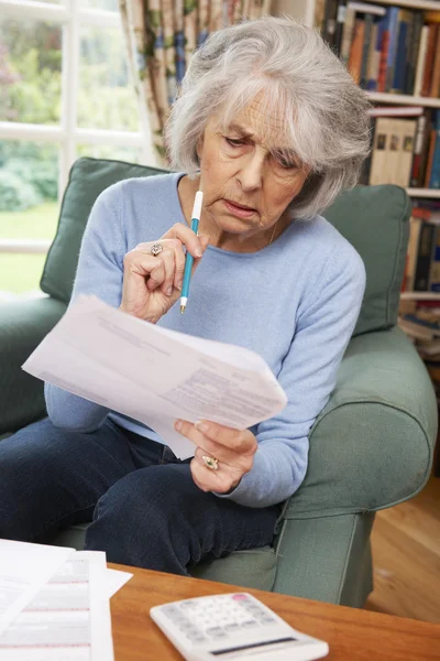 Senior mulher passando por contas e olhando preocupado — Fotografia de Stock