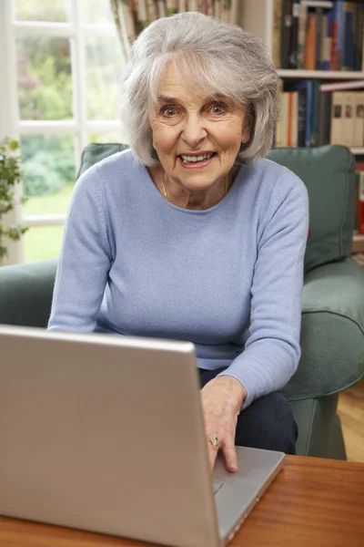 Seniorin benutzt Laptop zu Hause — Stockfoto