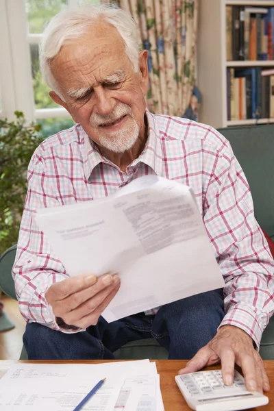 Uomo anziano che passa attraverso le finanze che sembrano preoccupati — Foto Stock