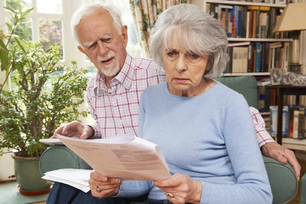 Senioren-Ehepaar schaut besorgt durch die Finanzen — Stockfoto