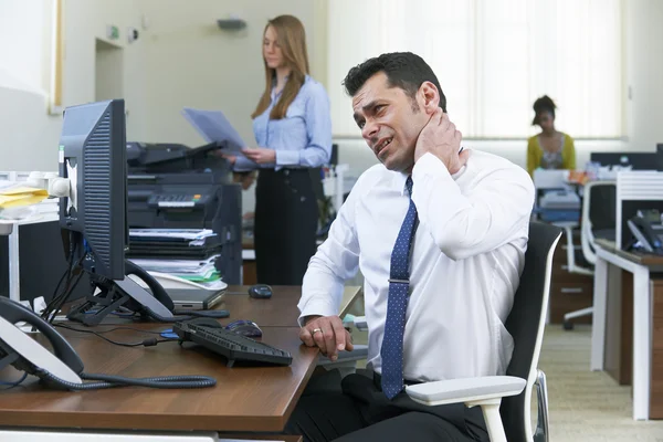 Empresário trabalhando na mesa sofrendo de dor no pescoço — Fotografia de Stock