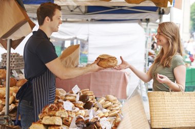 Customer Buying Loaf From Market Bread Stall