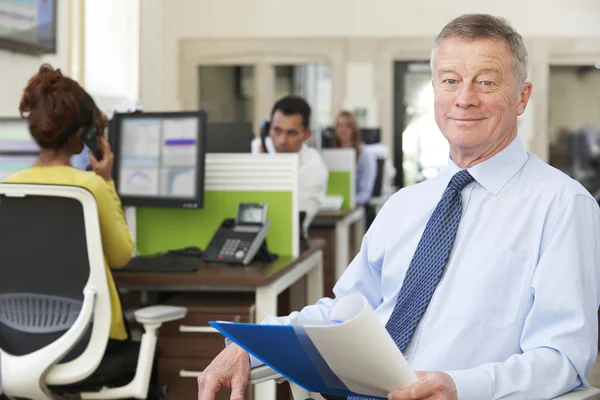 Porträt eines leitenden Geschäftsmannes in einem geschäftigen modernen Büro — Stockfoto