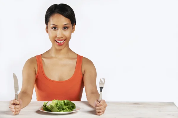 Happy Woman assis devant LKettuce laisse sur l'assiette — Photo