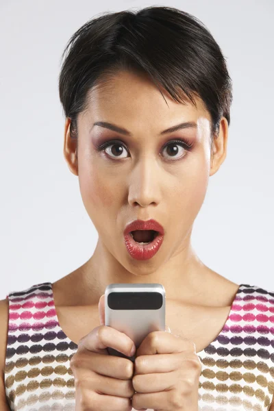 Frau liest SMS mit schockiertem Gesichtsausdruck — Stockfoto