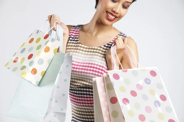 Estúdio tiro de mulher Funky com sacos de compras — Fotografia de Stock