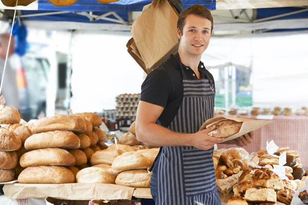 Homme vente de pain au marché de plein air — Photo