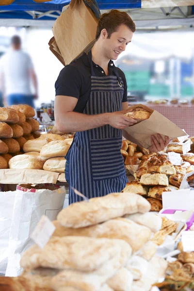 Eigenaar van brood kraam op openlucht markt — Stockfoto