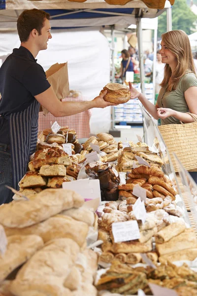 Propriétaire d'étal de pain au marché servant le client avec le pain — Photo
