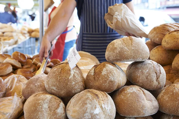 Hombre sirviendo en puesto de pan en el mercado al aire libre —  Fotos de Stock