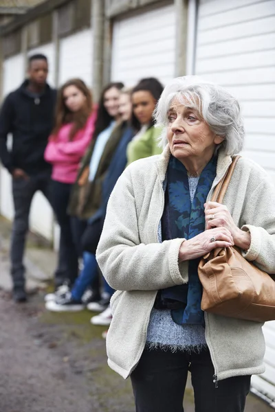 Donna anziana che si sente intimidita dal gruppo di giovani — Foto Stock