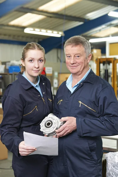 Ingegnere e apprendista con componente in fabbrica — Foto Stock