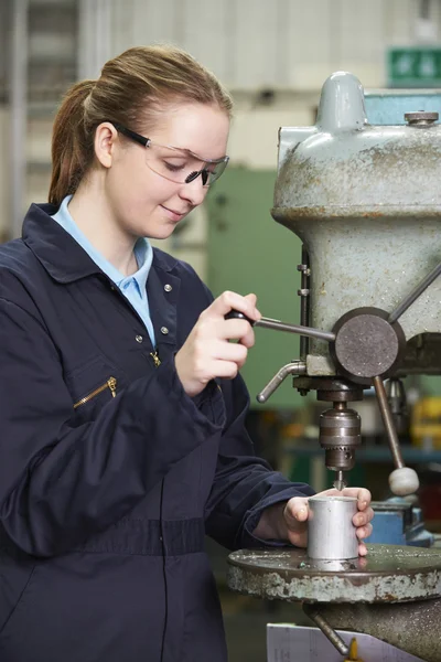 Engenheira aprendiz feminina usando broca na fábrica — Fotografia de Stock