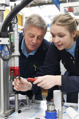 Mühendis ve Makina fabrikasında çalışan kadın çırak
