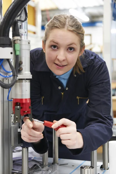工場のマシン上で動く女性見習いエンジニア — ストック写真