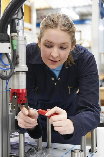 在工厂的机器上工作的女学徒工程师 — 图库照片