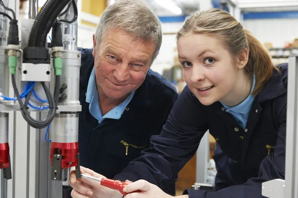 Ingeniero y aprendiz trabajando en la máquina en fábrica — Foto de Stock