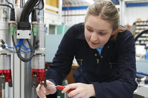 在工厂的机器上工作的女学徒工程师 — 图库照片