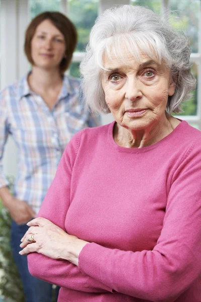 Allvarliga Senior kvinna med vuxna dotter hemma — Stockfoto