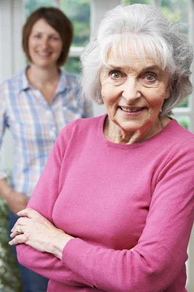Äldre kvinna med vuxna dotter hemma — Stockfoto