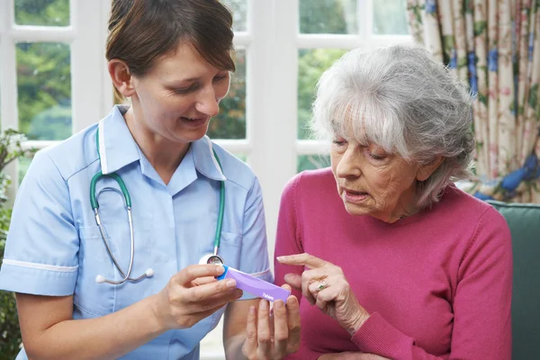 Sjuksköterska rådgivning senior kvinna på medicinering hemma — Stockfoto