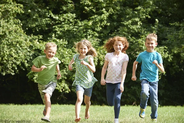 Groep van gelukkige kinderen loopt naar de Camera door veld — Stockfoto