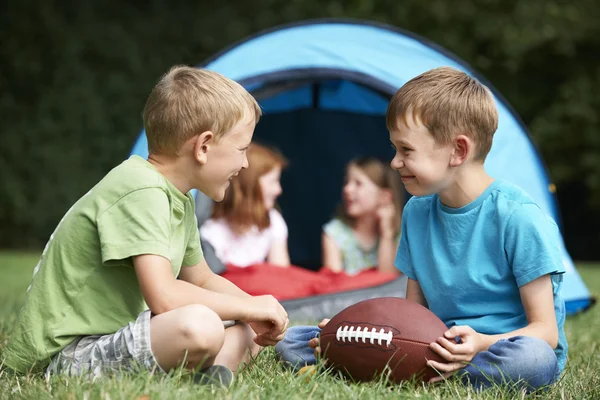 Dva chlapce mluvit a hrát si s amerického fotbalu na kemp T — Stock fotografie