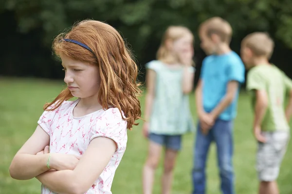 Menina infeliz sendo Gossiped sobre por outras crianças — Fotografia de Stock