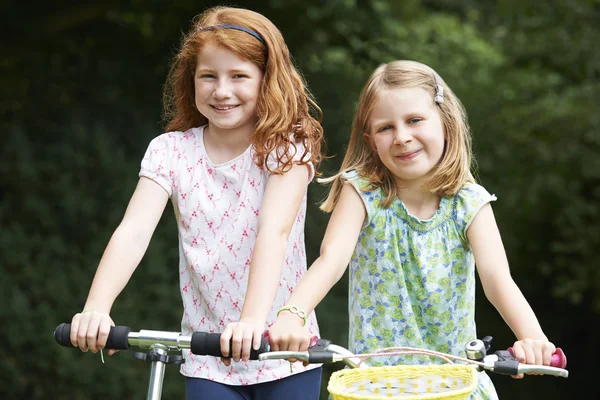 Дві дівчини грають на велосипеді і скутері на відкритому повітрі — стокове фото