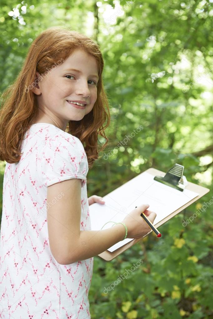 Female Pupil Making Notes On School Nature Field Trip