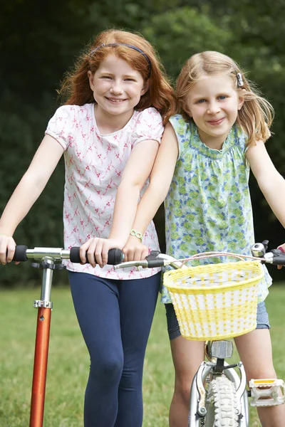 Дві дівчини їдуть велосипед і скутер разом — стокове фото
