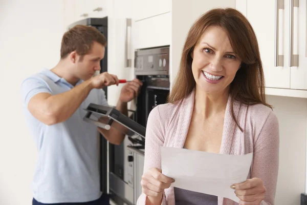 Lachende vrouw met reparatie wetsvoorstel — Stockfoto