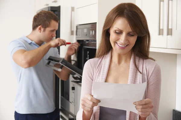 Lachende vrouw met reparatie wetsvoorstel — Stockfoto