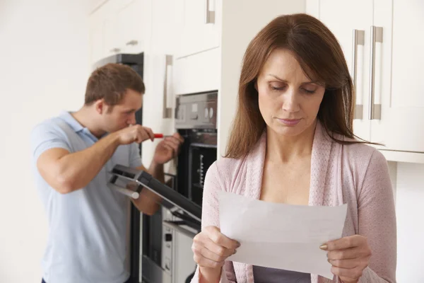 Vrouw op zoek bezorgd over reparatie wetsvoorstel Rechtenvrije Stockfoto's