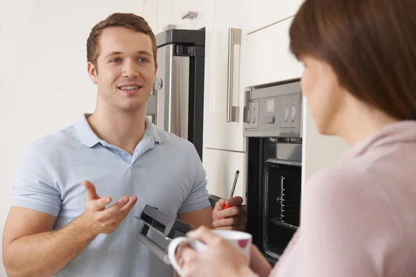 Ingeniero dando consejos a la mujer en la reparación de la cocina —  Fotos de Stock