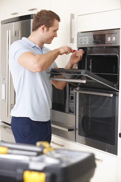 Ingenieur repariert Haushaltsbackofen in Küche — Stockfoto