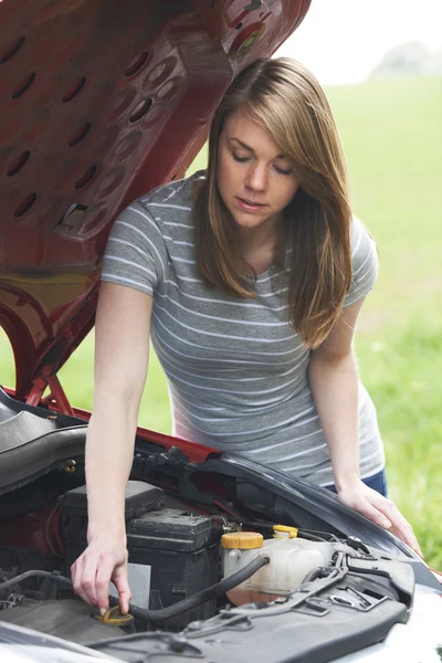 Roto abajo motorista femenina mirando motor de coche — Foto de Stock