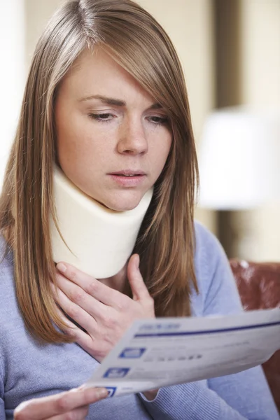 Junge Frau mit Nackenstütze liest Brief — Stockfoto