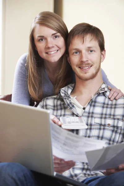 Heureux jeune couple regardant les finances sur ordinateur portable — Photo