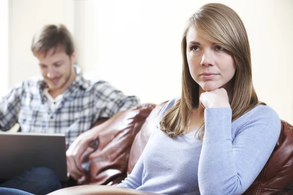 Ongelukkig vrouw zittend op de Bank als Partner toepassingen Laptop — Stockfoto