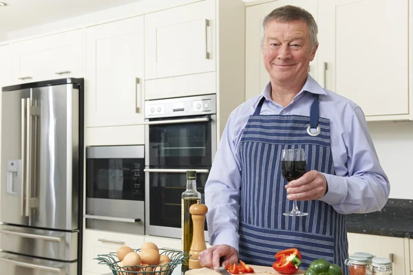 Senior Man genieten van koken In de keuken met glas wijn — Stockfoto