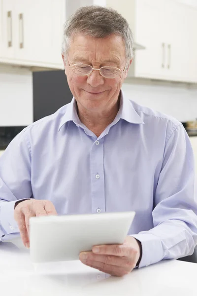 Senior man använder digitala surfplatta hemma — Stockfoto