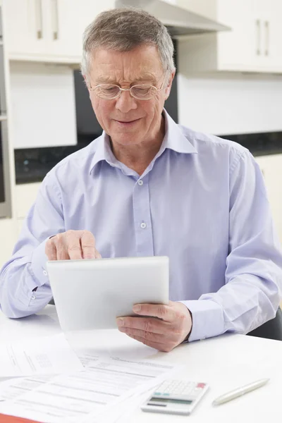 Seniorchef checkt mit digitalem Tablet persönliche Finanzen — Stockfoto