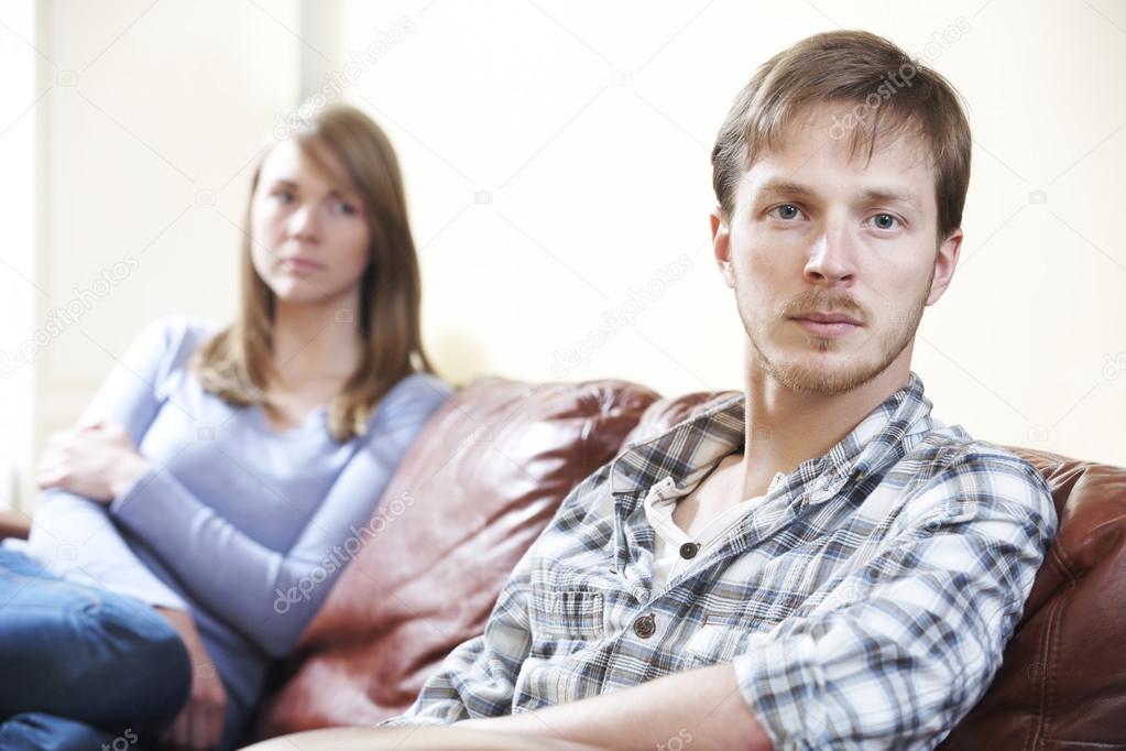 Couple With Relationship Difficulties Sitting On Sofa
