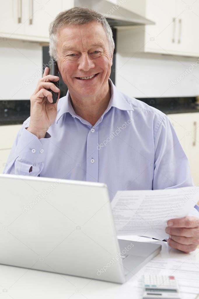 Senior Man Checking Finances On The Phone