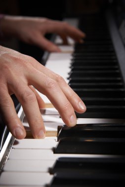 Elinde elektrikli piyano klavye çalmaya yakın çekim