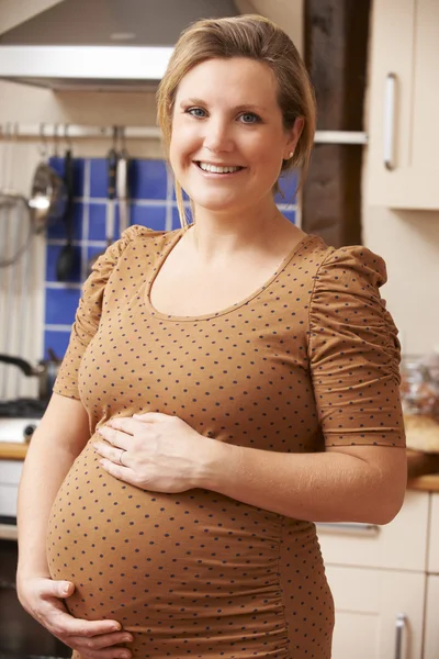 Portrait de femme enceinte souriante heureuse dans la cuisine à la maison — Photo